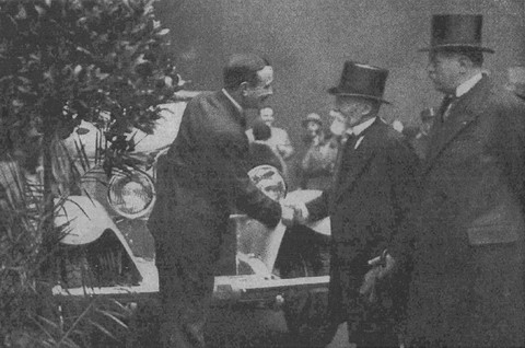Georges Irat serrant la main du président Paul Doumer au Salon de l'Auto 1930 avec derrière lui la berline IRAT HUIT à moteur Lycoming.